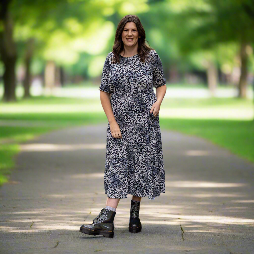 Woman in a patterned breastfeeding dress standing on a path in a park