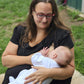 mum sat down breastfeeding in. a black breastfeeding dress.