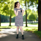 Woman in a floral breastfeeding dress standing in a park showing the secret breastfeeding access